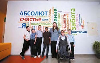 Ученики и учитель Светлана Охримчук на фоне баннера школы "Абсолют"